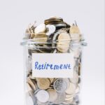 close-up-retirement-glass-container-full-coins-white-background